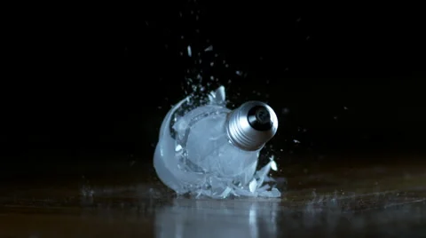 Close shot of lightbulb falling and breaking screw-first in super slow motion Stock Footage