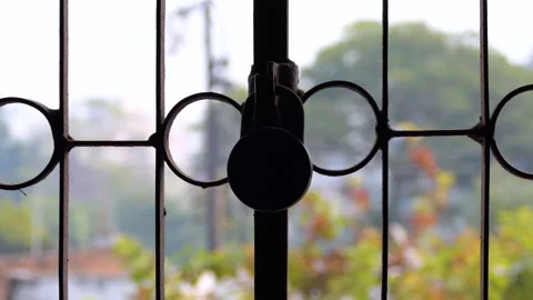 Close shot of a locked window grill with an old lock hanging on it Stock Footage 146152594