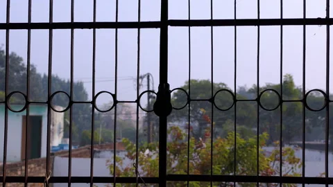 Close shot of a locked window grill with an old lock hanging on it Stock Footage 146152600