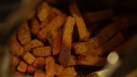 A close-up shot looking inside an open foil bag of crunchy rye croutons 스톡 동영상 344884281
