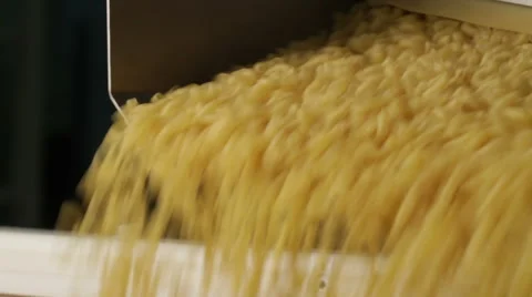 Close up shot of macaroni dropping from a machinery to prepare pasta Stock Footage 61277692