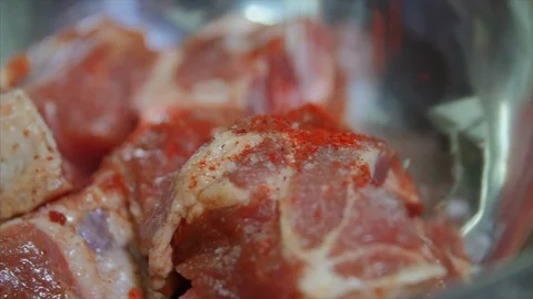 Close up shot in macro of adding red hot pepper to meat to make marinade 스톡 동영상 104130740