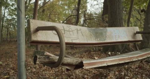 Close up shot of a makeshift bench in a forest, with graffiti scribbled on Stock Footage 147908236