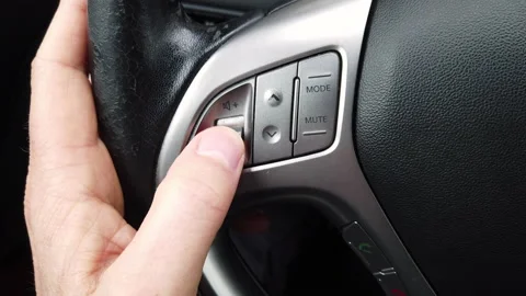 Close-up shot of male driver using audio display shortcuts on a steering whe Video stock 174719988