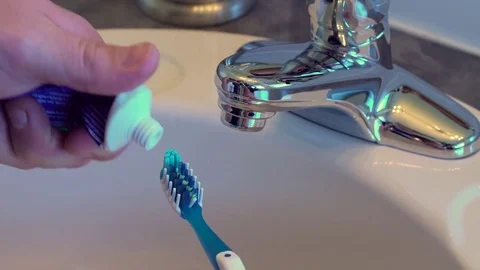 Close up shot of male hands squeezing a toothpaste tube, but nothing comes out. Video stock 69918296