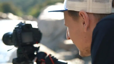 Close Up shot Male setting up camera and tripod to capture the beauty of nature Stock Footage 98567971