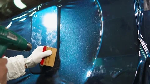 Close up shot of man applying vinyl film while tuning car Stock Footage 75431152
