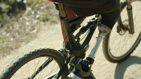 Close-up shot of man with artificial leg pedaling bike in nature Stock Footage 165105690