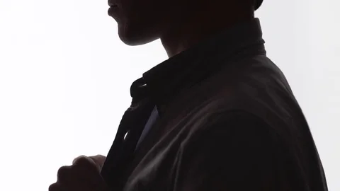 Close-up shot of a man buttoning a shirt. silhouette Stock Footage 74444884