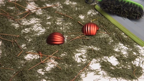 A close-up shot, a man collects broken Christmas balls and dry pine branches 库存影片 120798518