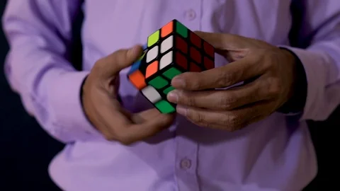 Close shot of a man, completely solving Rubik's Cube. Stock Footage 120592668