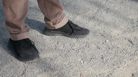 Close up shot of a man dropping a cigarette but and crushing it with his foot Stock Footage 125552498