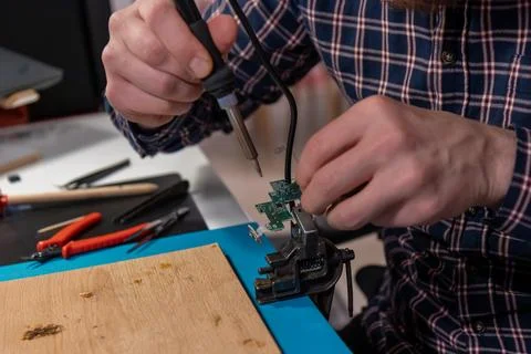 A close-up shot of a man engaged in the delicate process of soldering a sma.. Stock Photos