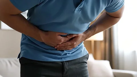 Close-up shot of a man experiencing abdominal pain or indigestion. Stock Footage 316877890