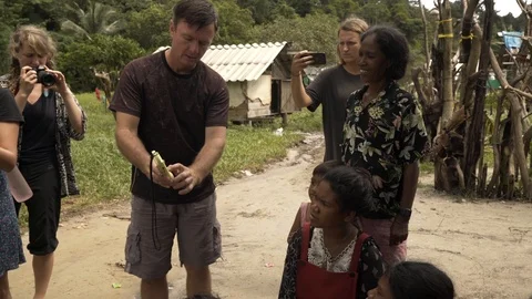 A close shot of man explaining about solar lights to villagers Stock Footage 115674933