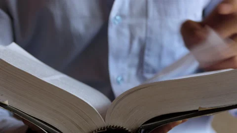 Close shot of a man flipping the pages of a thick book and searching for a word Stock Footage 146964019