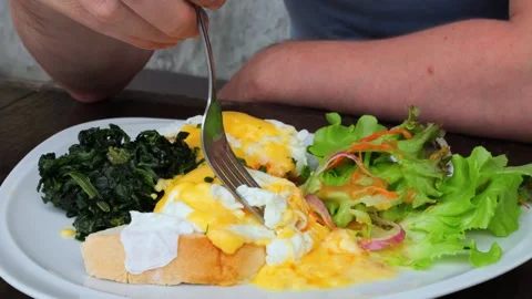 Close up shot man fork pricks piece of poached egg and dips into yolk. Man Stock Footage 250409503