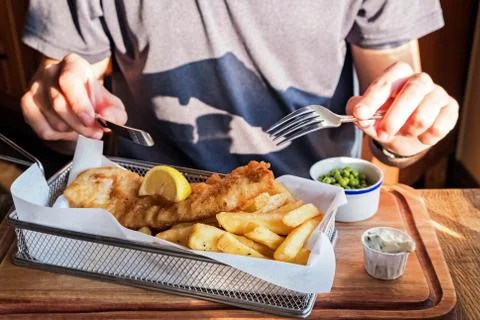 Close-up shot of man going to eat fish and cheaps. Stock Photos