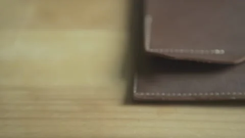 Close up shot of man hand putting silver ball pen into pen holder on light brown Stockbeeldmateriaal 137539180