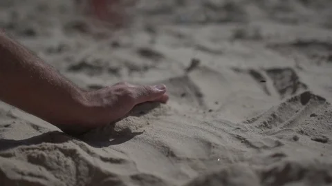 Close up shot on a man hand touching the sand beach. Slow motion real life Stock Footage 100167132