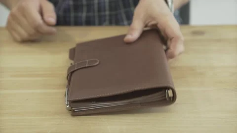Close up shot of man hands opening elegant light brown leather note book pad dai Stock Footage 137539058