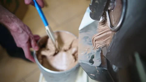 Close shot of man hands with a stirring paddle mixing ice cream from freezer in Stock Footage 267017892