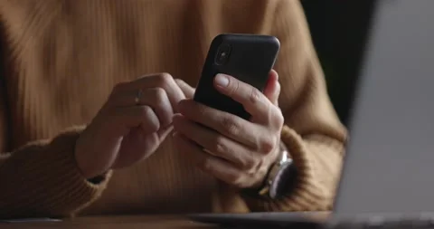 Close up shot of man hands with watch using mobile phone while working at laptop Stock Footage 164675927