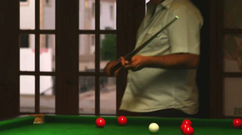 A close up shot of a man hitting a cue ball on a green billiards table Video stock 33847487