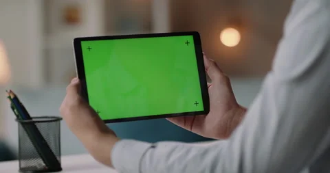 Close up shot of man holding a tablet computer with green screen. Guy working or Vídeo Stock 139497146