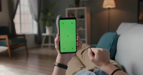 Close up shot of man lying on couch and using smart phone with chroma key green Stock Footage 133128390