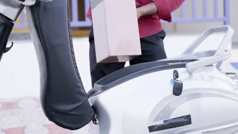 Close up shot of man placing charged battery in side the scooty at home - Stock Footage 197264709