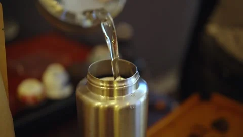 Close-up shot of a man pours boiling water into a thermos before work or travel Stock Footage 296012632