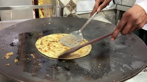 Close up shot of a man preparing lacha paratha at a shop in India 스톡 동영상 280530567