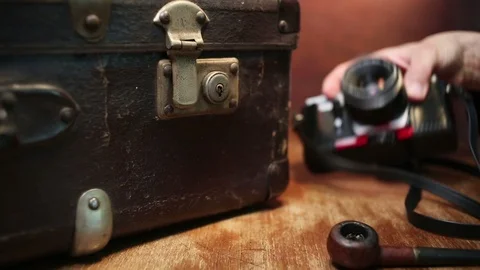 Close up shot of a man putting pipe on table and taking out photo camera. Stock-Footage 91677019