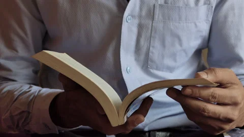 Close shot of a man reading the page of a book Stock Footage 146967048