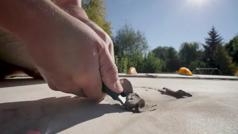 Close up shot of a man removing gray sealant on RV roof with a sharp tool Stock Footage 148870506