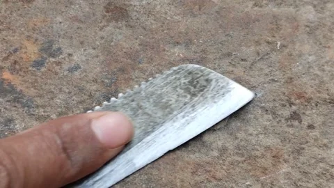 Close up shot of a man sharpening knife on a stone with fingers at home in I Stock Footage 254528826