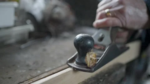 Close up shot of man shaving a piece of wood in a workshop Stock Footage 175198218
