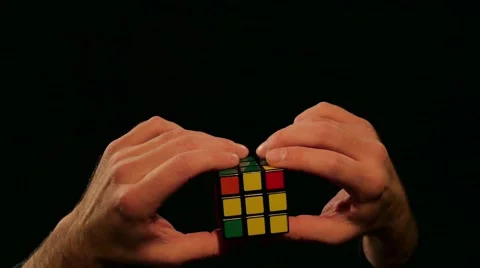 Close up shot of a man solving the Rubik´s cube, isolated on a black background Stock Footage 60672506