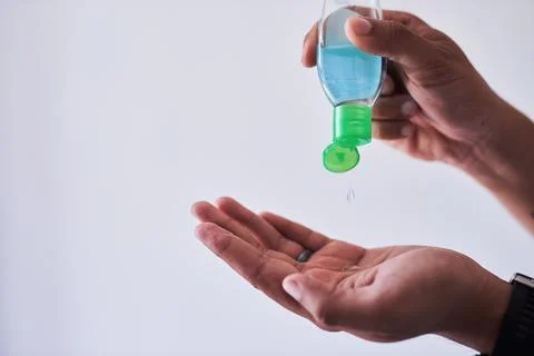 A close up shot of a man squeezing hand sanitiser into his palm Stock Photos