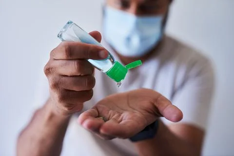 A close up shot of a man squeezing hand sanitiser into his palm Stock Photos