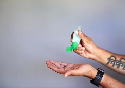 A close up shot of a man squeezing hand sanitiser into his palm Stock Photos