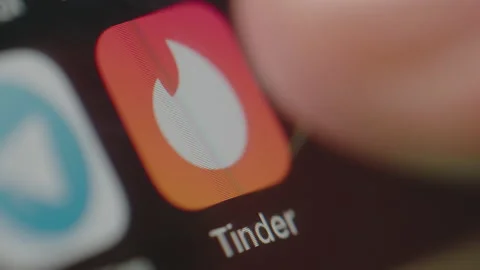 Close shot of Man starting Tinder app on a smartphone Видео 134375479