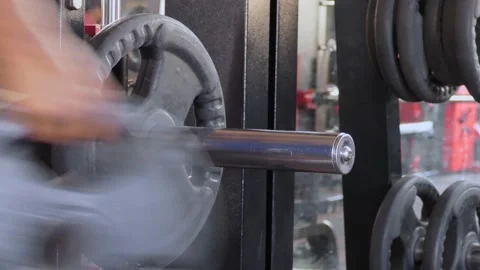 Close shot of a man talking out weight plates from the iron weight lifting bar Stock Footage 147645482