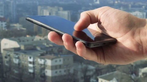 Close-up shot of man texting on smart phone against cityscape Stock Footage 83427496
