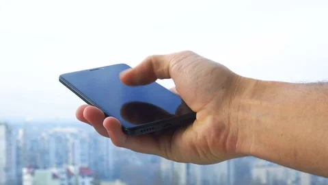 Close-up shot of man texting on smart phone against cityscape Stock Footage 83428078
