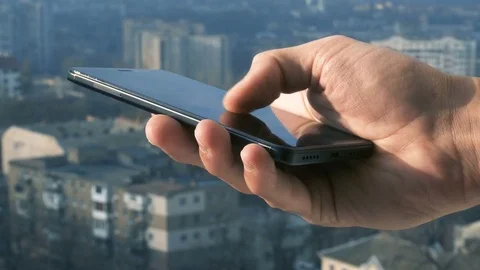 Close-up shot of man texting on smart phone against cityscape Video stock 83530988