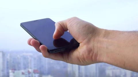 Close-up shot of man texting on smart phone against cityscape Video stock 83531201