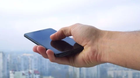Close-up shot of man texting on smart phone against cityscape Stock Footage 83574375