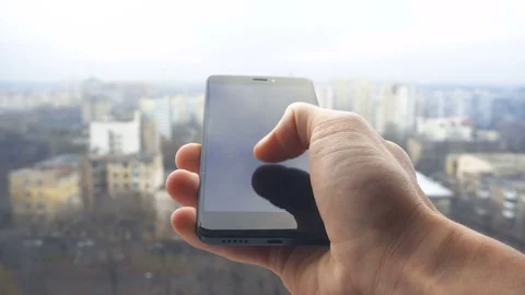 Close-up shot of man texting on smart phone against cityscape Stock Footage 83575158